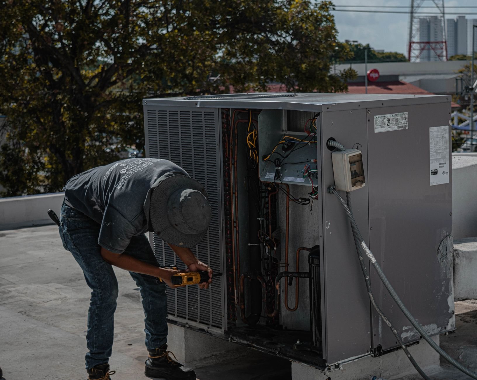 HVAC technician servicing an air conditioning unit on a rooftop