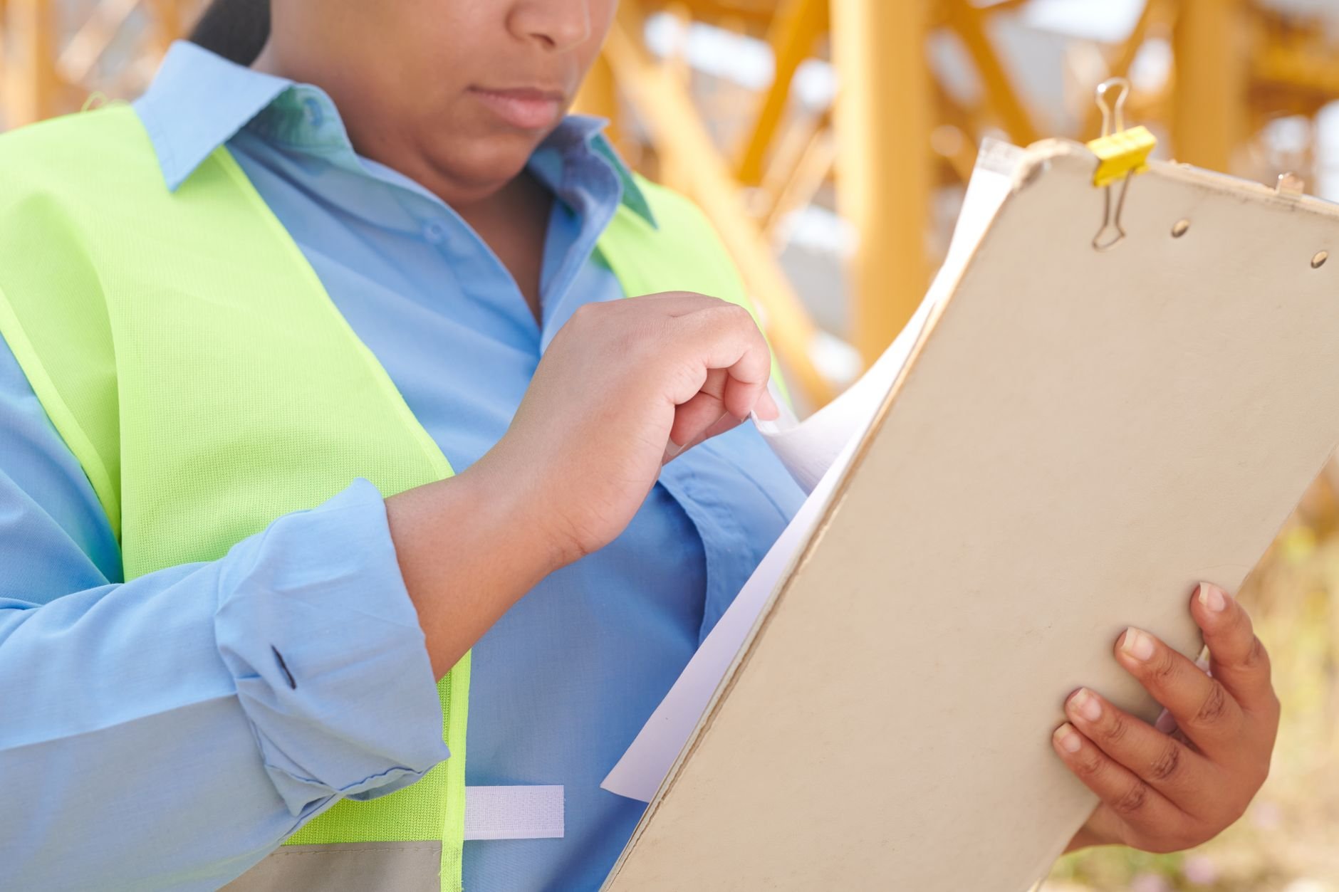Contractor reviewing job documents on a clipboard at a work site